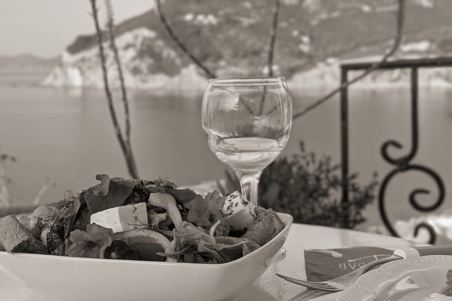 Τραπέζι με ελληνική σαλάτα και θέα στη θάλασσα